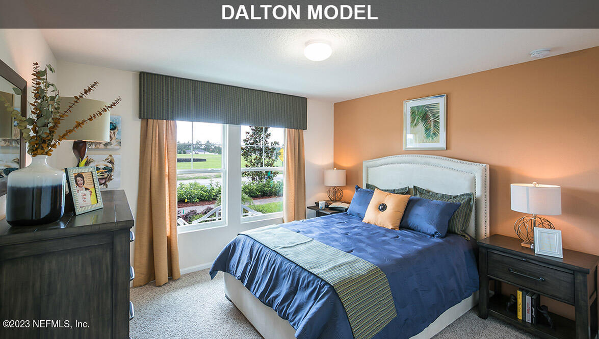 65792 Edgewater Drive Yulee, FL 32097 - Photo 15 of 45 a bedroom with a balcony a bed and a television