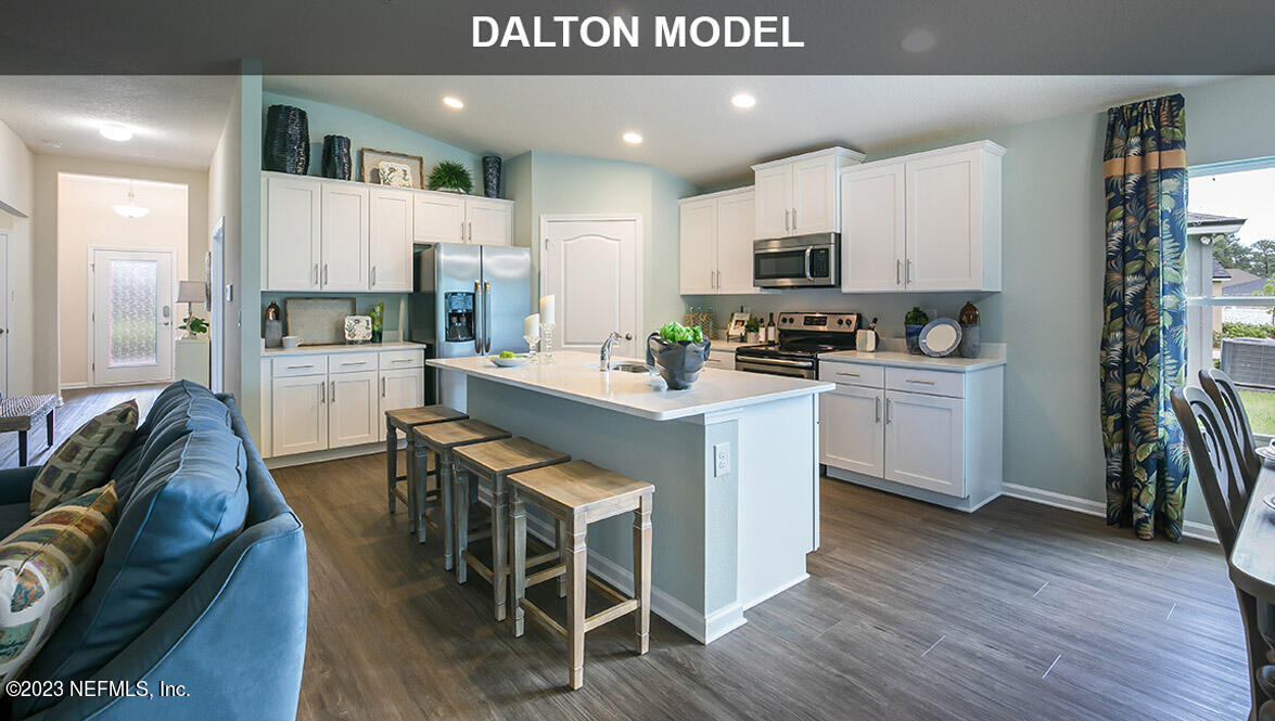 65792 Edgewater Drive Yulee, FL 32097 - Photo 4 of 45 a kitchen with stainless steel appliances a microwave a stove a sink dishwasher a oven with white cabinets and wooden floor