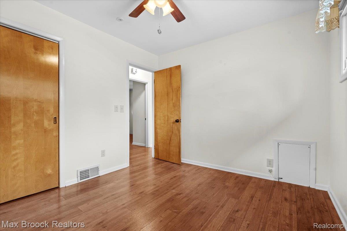 1330 Oak Street Rochester, MI 48307 - Photo 12 of 35 Wood-finish flooring throughout, with a ceiling fan light fixture and a window providing natural illumination