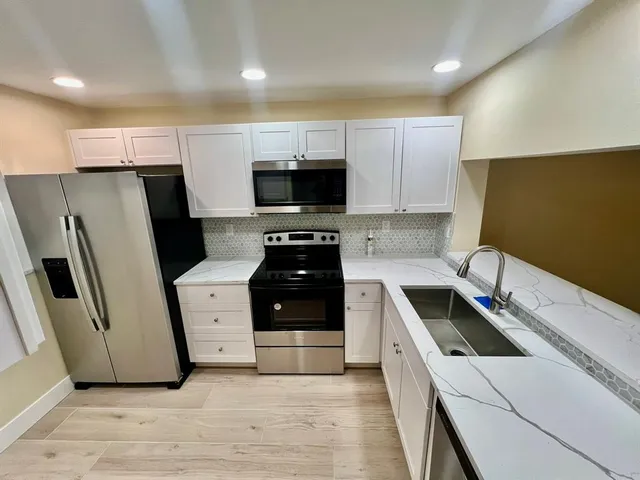 a kitchen with stainless steel appliances a refrigerator stove and microwave