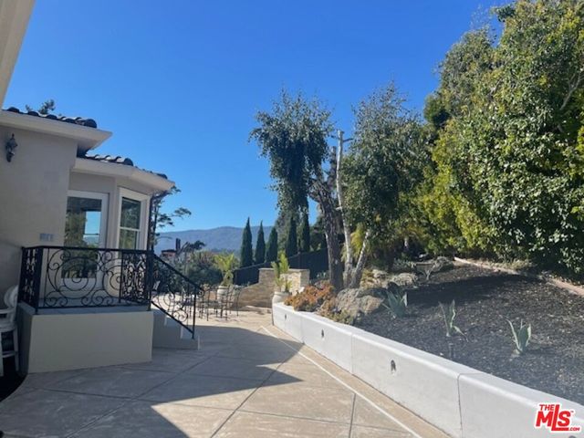 a view of a patio with couches table and chairs and potted plants