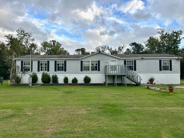a view of a house with a patio and a yard
