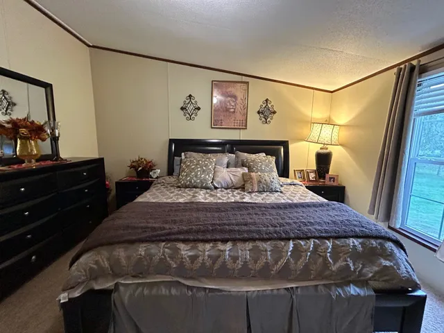 a bedroom with a bed and a mirror on dresser