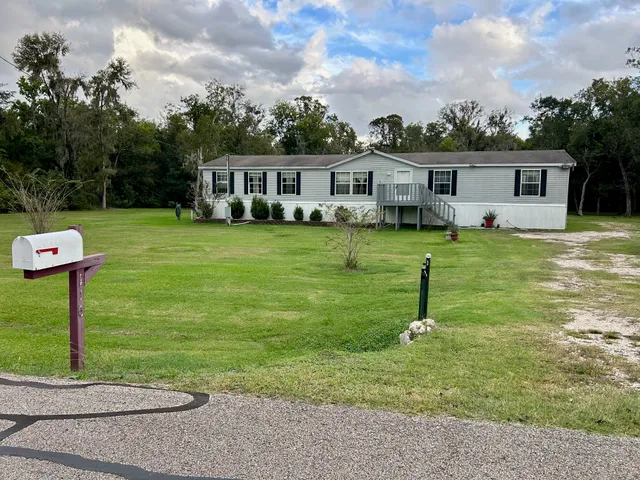 a front view of a house with a yard and trees