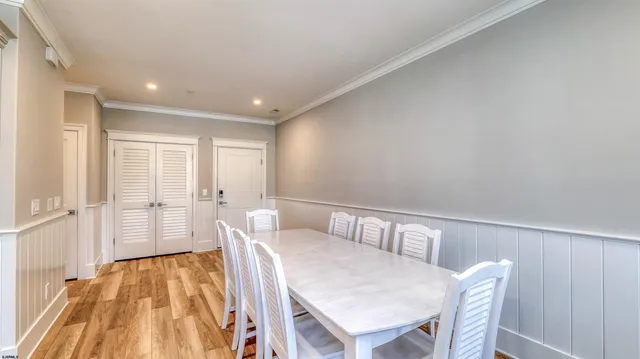 a kitchen with stainless steel appliances kitchen island granite countertop a dining table chairs and white cabinets