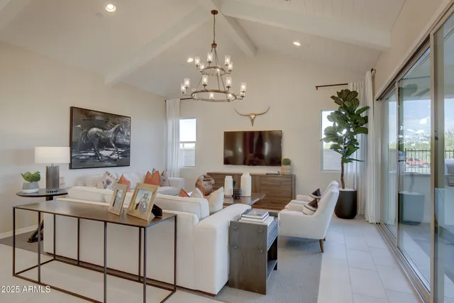 a living room with furniture a chandelier and a flat screen tv