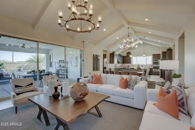 a living room with furniture a chandelier and a flat screen tv