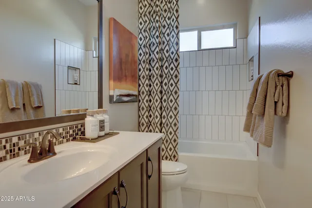 a bedroom with a bed couches chair and a large window