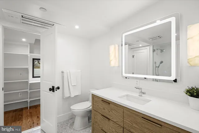a bathroom with a granite countertop sink toilet and shower