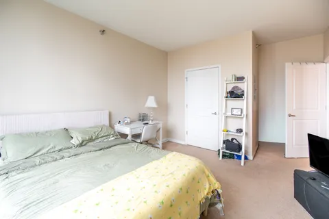 a spacious bedroom with a bed and a flat screen tv