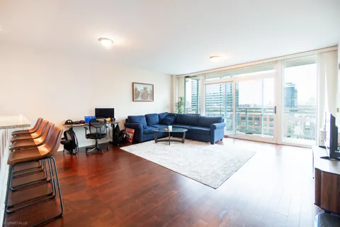 a living room with furniture large window and a wooden floor