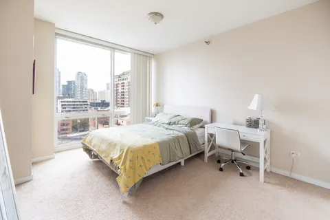 a bedroom with a bed and a large window