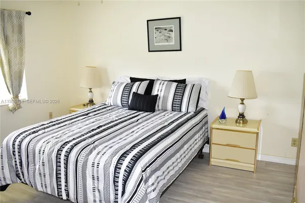 a bedroom with a bed and a lamp on dresser