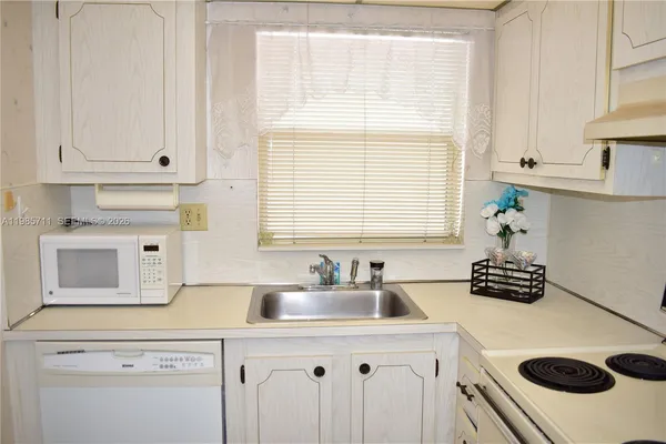 a kitchen with a sink cabinets and window