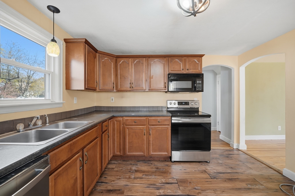 803 Armory Street Springfield, MA 01107 - Photo 12 of 34 a kitchen with stainless steel appliances granite countertop a stove a sink and a microwave