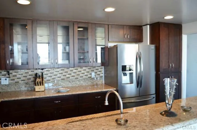 a kitchen with granite countertop a refrigerator and a sink