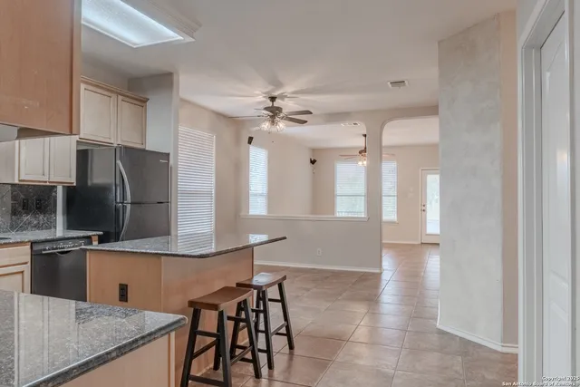 a kitchen with stainless steel appliances granite countertop a stove a sink dishwasher a refrigerator and cabinets with wooden floor