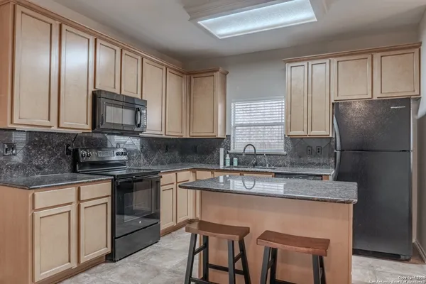 a kitchen with stainless steel appliances granite countertop a refrigerator a sink and a granite counter tops
