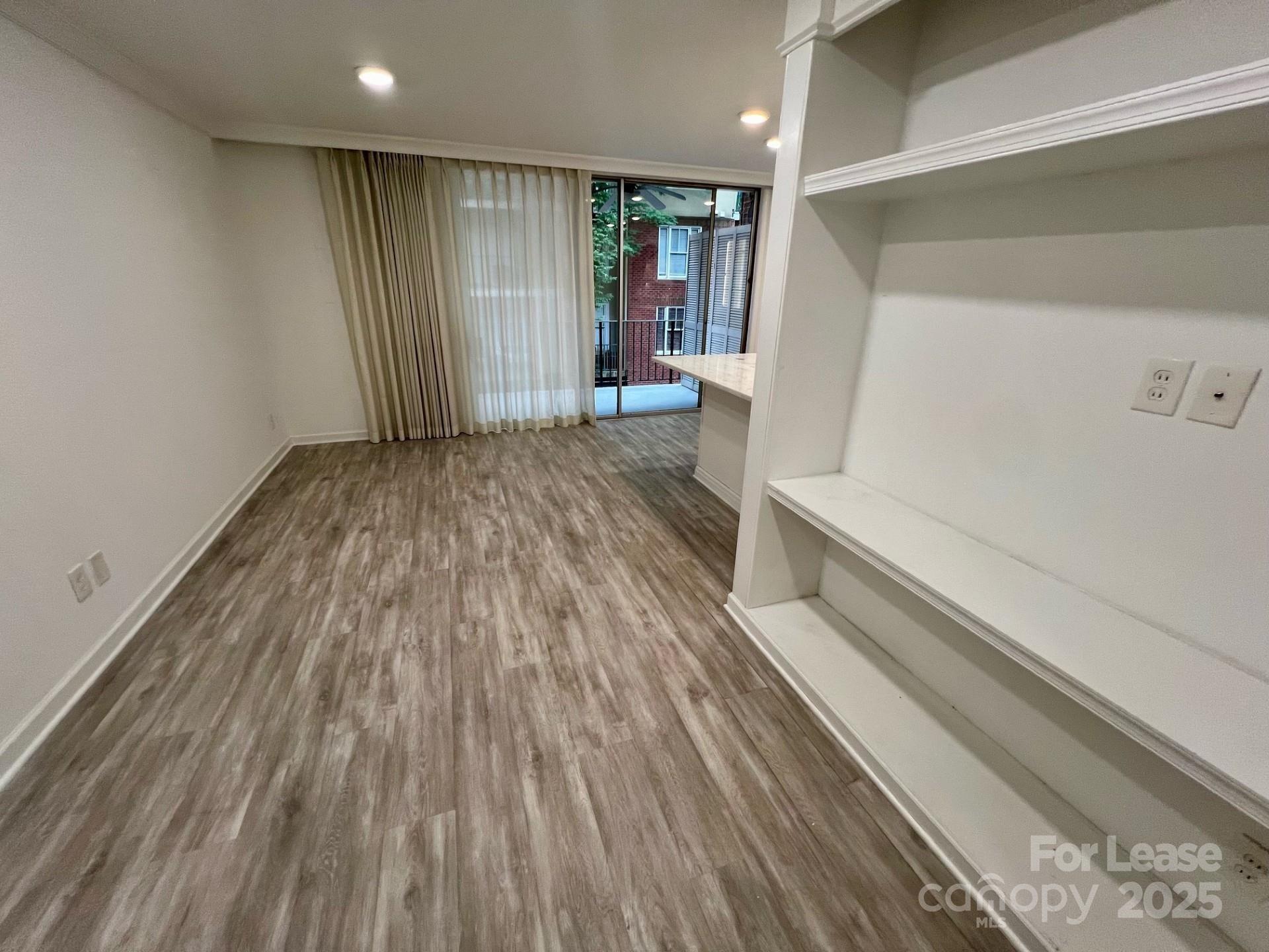 400 Queens Road, Unit B4 Charlotte, NC 28207 - Photo 2 of 10 a view of an empty room with wooden floor and a window