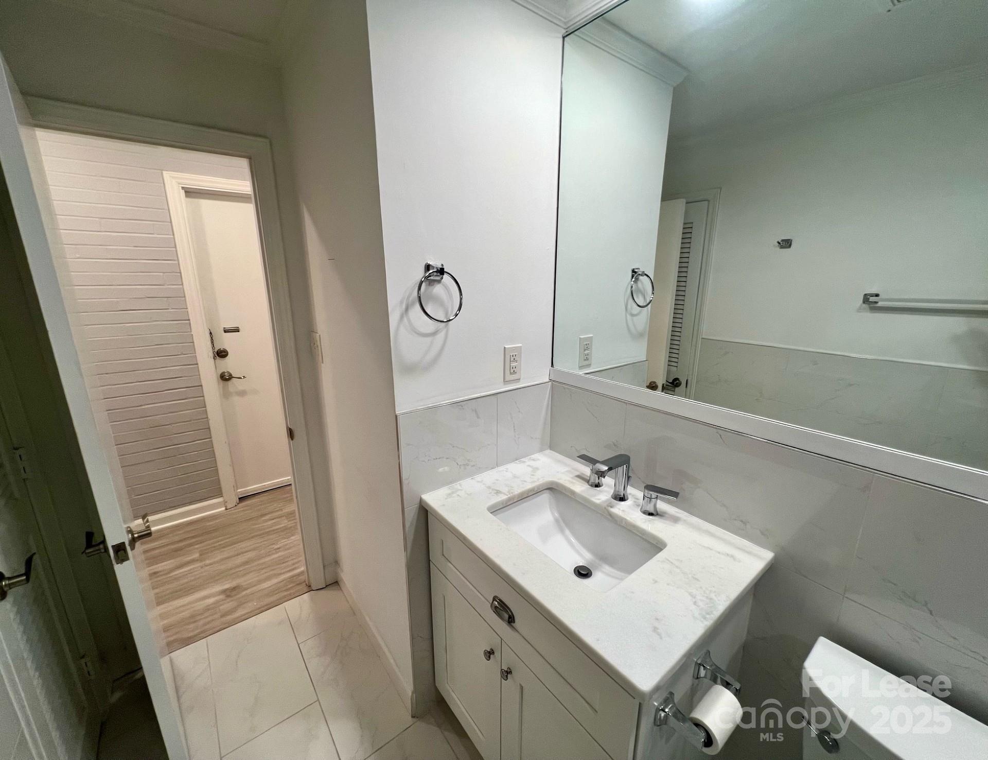 400 Queens Road, Unit B4 Charlotte, NC 28207 - Photo 6 of 10 a bathroom with a sink a mirror and a shower