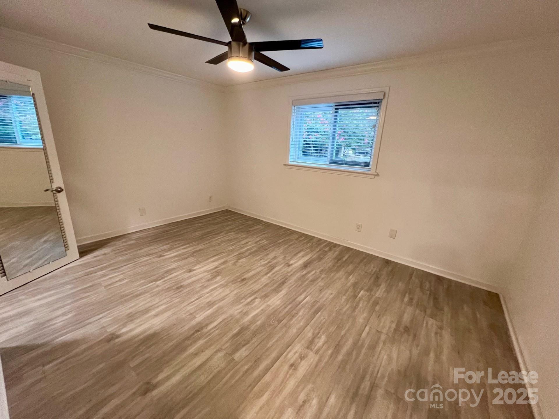 400 Queens Road, Unit B4 Charlotte, NC 28207 - Photo 7 of 10 an empty room with wooden floor ceiling fan and windows
