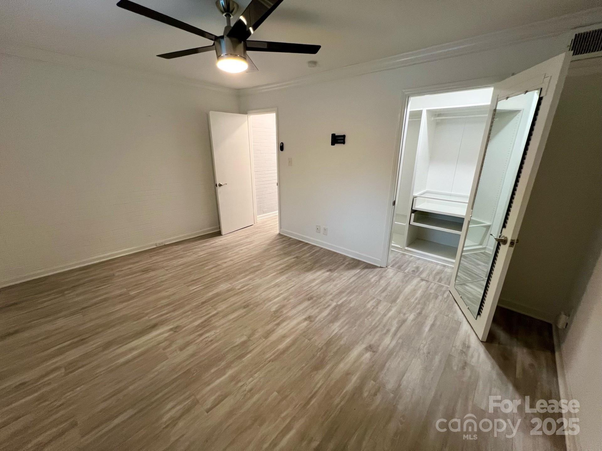 400 Queens Road, Unit B4 Charlotte, NC 28207 - Photo 8 of 10 an empty room with wooden floor and a ceiling fan