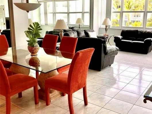 a living room with furniture a large window and a potted plant