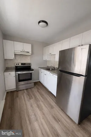 a kitchen with a refrigerator and a stove top oven