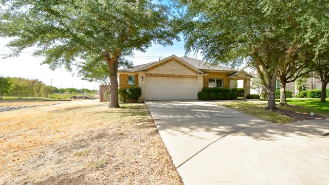 a front view of a house with a yard and trees