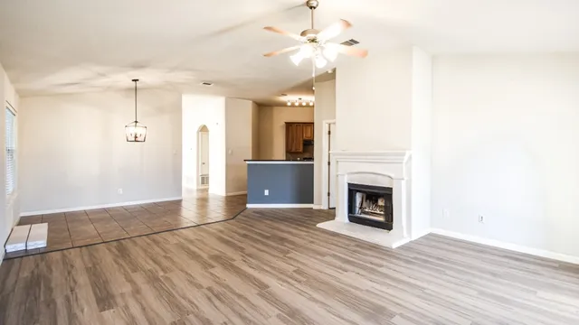 a view of a livingroom with a fireplace wooden floor and a chandelier