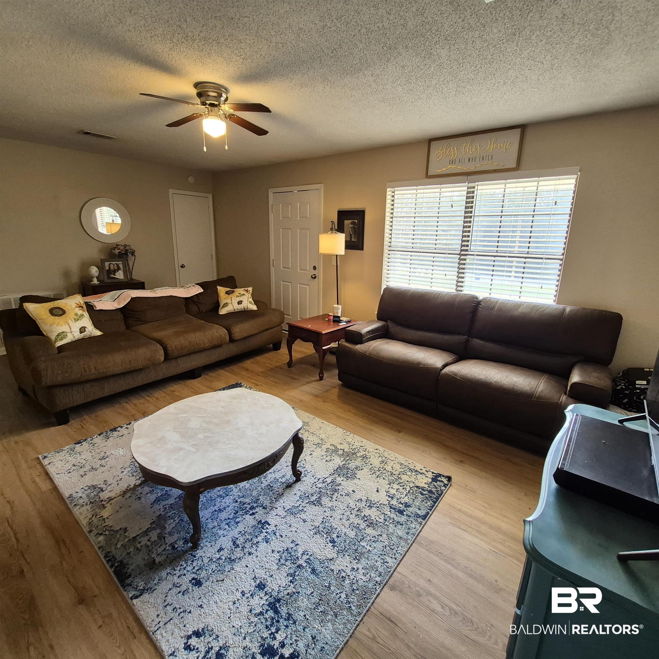 721 Perryman Street Evergreen, AL 36401 - Photo 4 of 26 Living area with light wood finished floors, a ceiling fan, and a textured ceiling