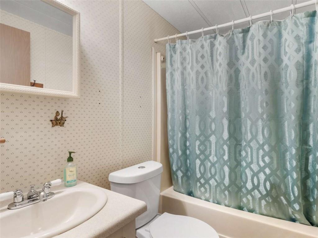 1775 Long Piney Road Mansfield, GA 30055 - Photo 15 of 26 a bathroom with a sink a toilet and shower curtain