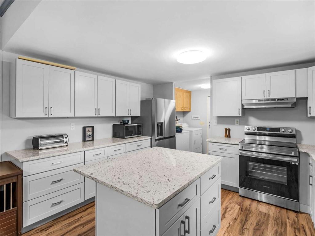 1775 Long Piney Road Mansfield, GA 30055 - Photo 6 of 26 a kitchen with granite countertop a sink stove and cabinets