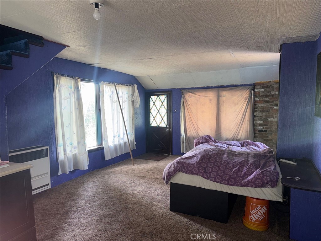 744 Woodland Road Crestline, CA 92325 - Photo 7 of 26 a spacious bedroom with a bed and large windows