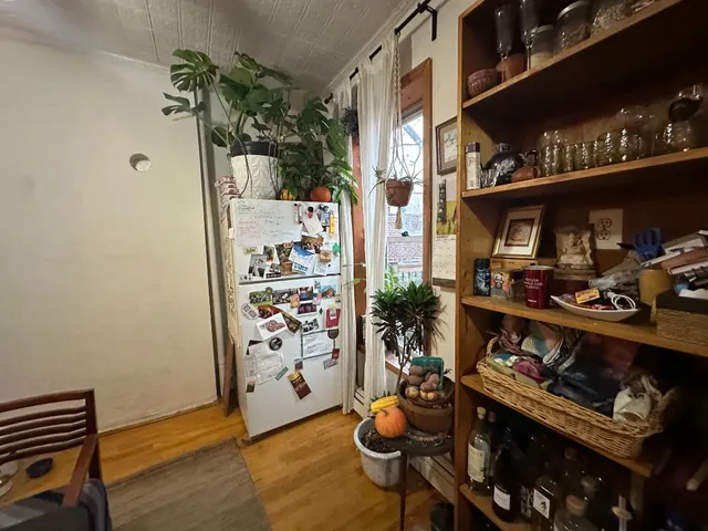 a room with lots of books and a dining table with wooden floor