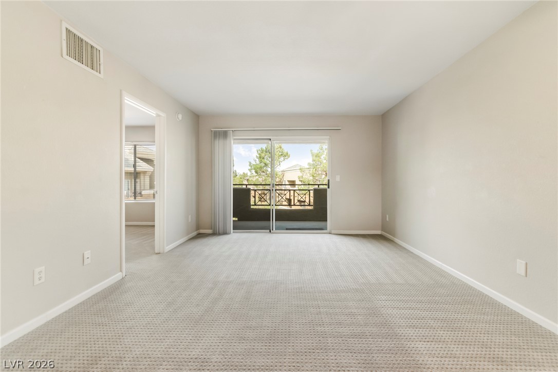 8070 West Russell Road, Unit 2006 Las Vegas, NV 89113 - Photo 11 of 24 A spacious room offers comfortable carpeted flooring and access to a private balcony.