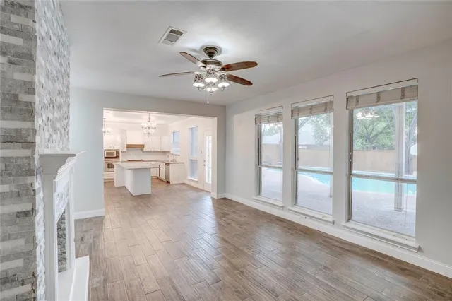 a view of a livingroom with a furniture a ceiling fan and wooden floor