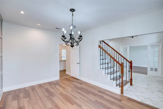 a view of a room with wooden floor chandelier and entryway