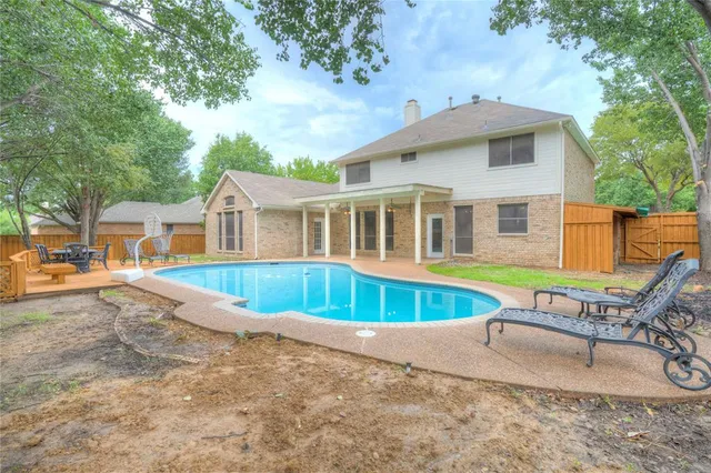 a view of a house with pool and chairs