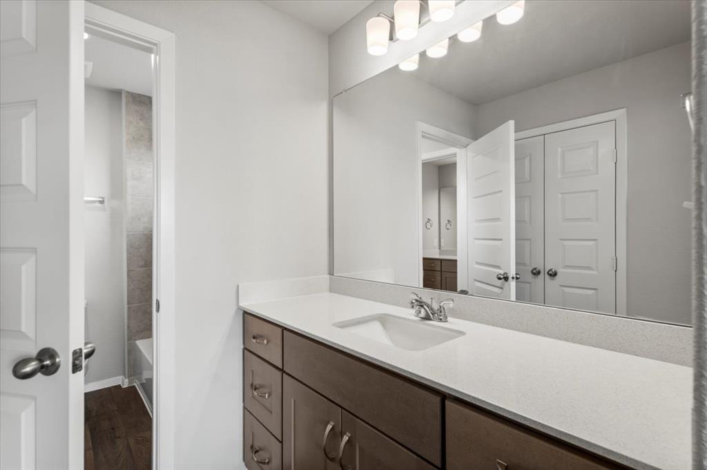 2707 Totley Road Manor, TX 78653 - Photo 26 of 39 Full bath featuring vanity, dark wood-style floors, and shower combination
