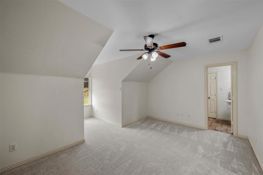 5607 Ranger Drive Rockwall, TX 75032 - Photo 29 of 40 Spacious room featuring vaulted ceilings, light-toned carpet flooring, and a ceiling fan with light fixture