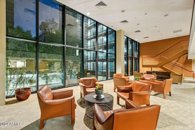 a dining room with furniture and large windows