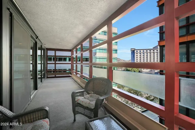 a living room with furniture a rug and a floor to ceiling window