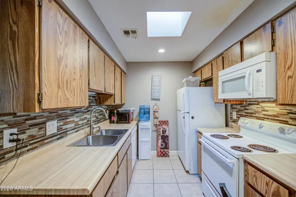 a kitchen with granite countertop a sink stove and refrigerator