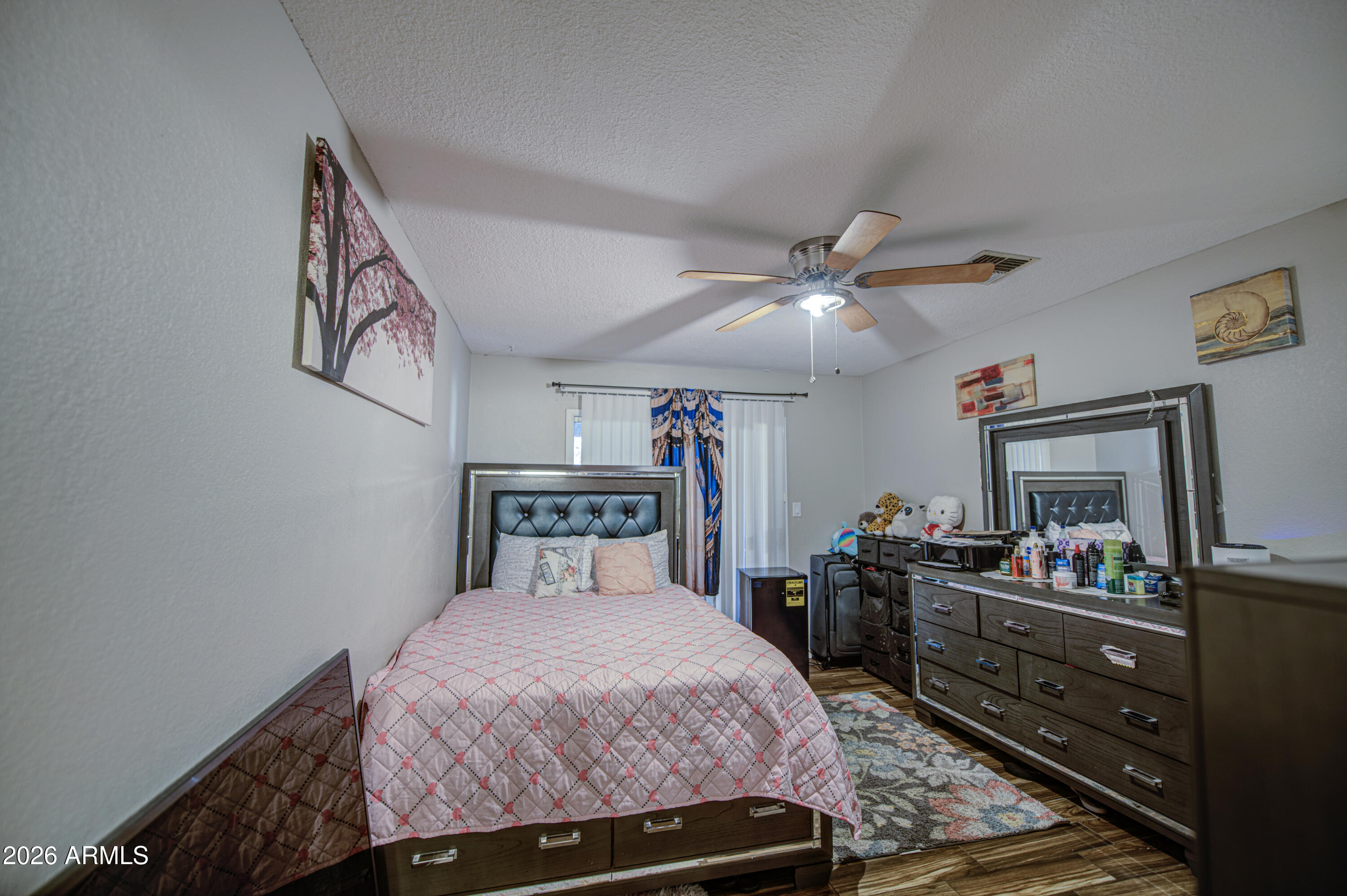 9009 West Elm Street, Unit 6 Phoenix, AZ 85037 - Photo 15 of 23 a bedroom with a bed and a dresser in it