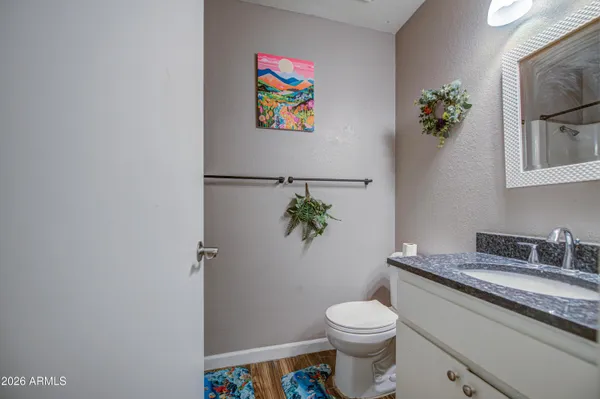 a bathroom with a granite countertop sink a toilet and mirror