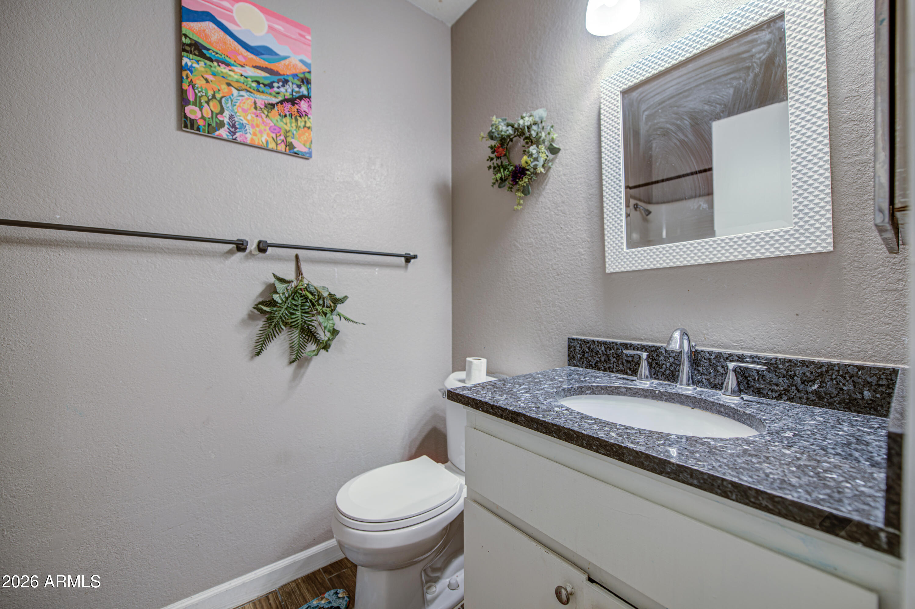 9009 West Elm Street, Unit 6 Phoenix, AZ 85037 - Photo 18 of 23 a bathroom with a granite countertop sink a toilet and mirror