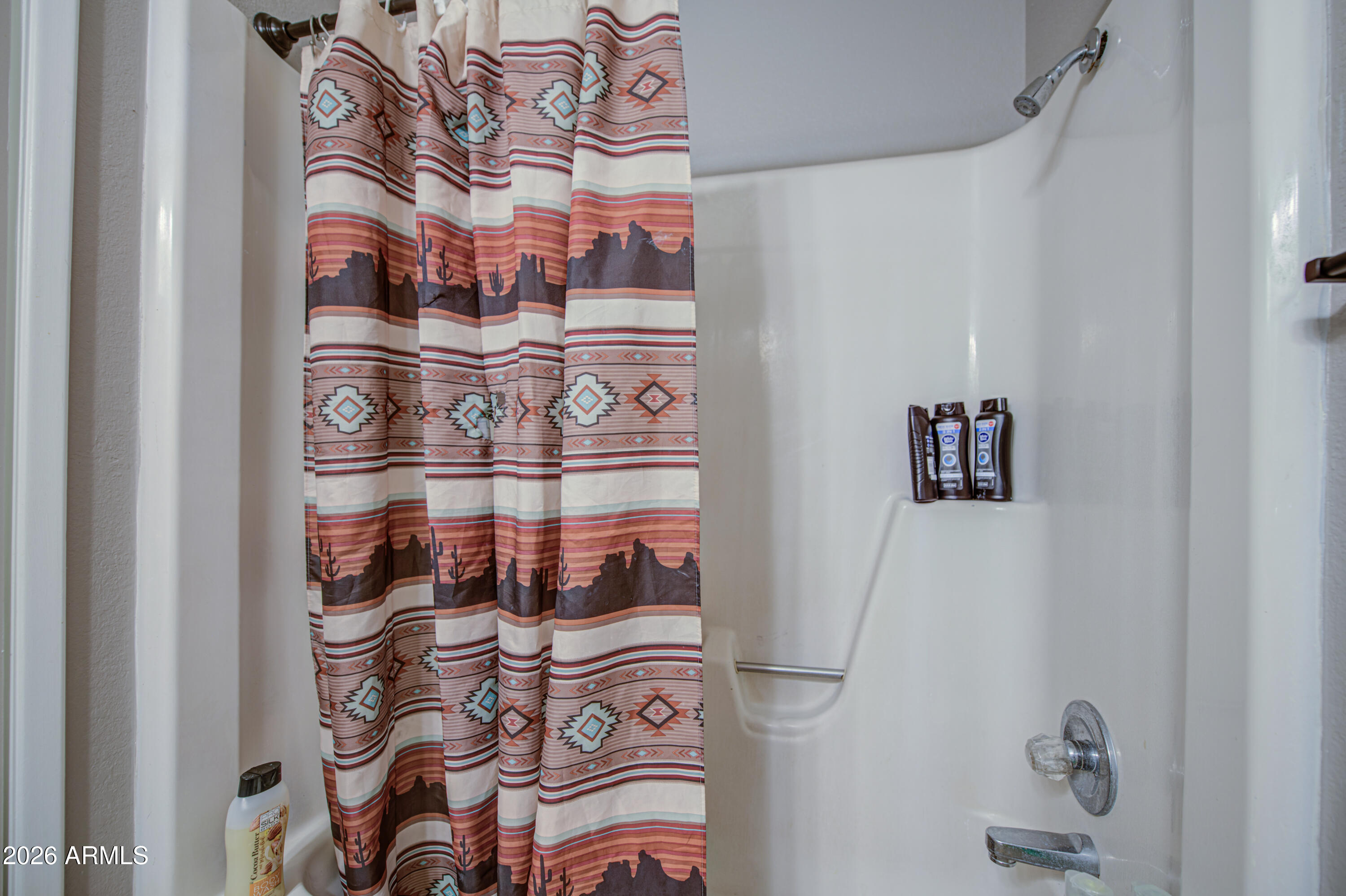 9009 West Elm Street, Unit 6 Phoenix, AZ 85037 - Photo 19 of 23 a bathroom with a bathtub and a shower curtain