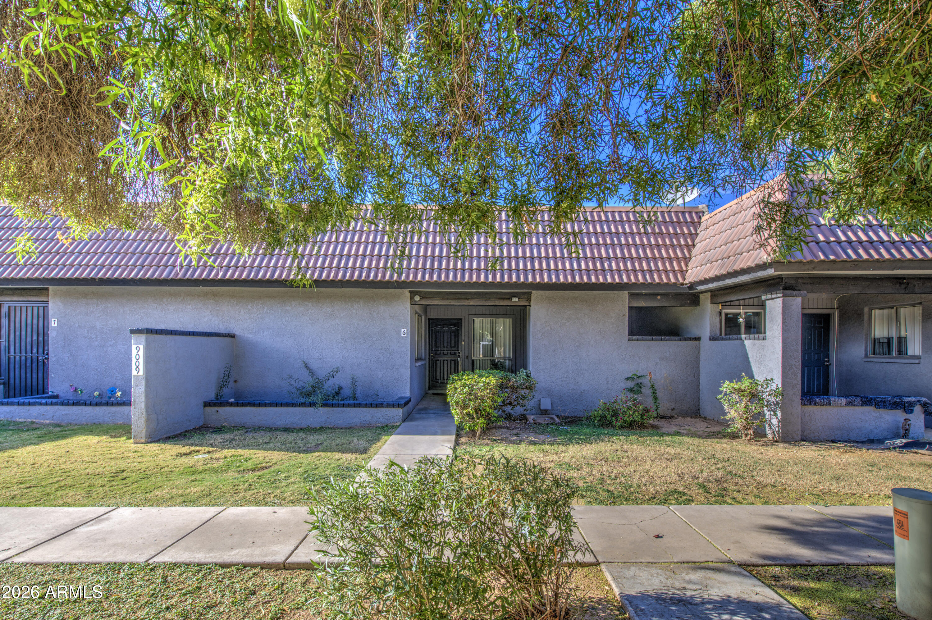9009 West Elm Street, Unit 6 Phoenix, AZ 85037 - Photo 2 of 23 a front view of a house with garden