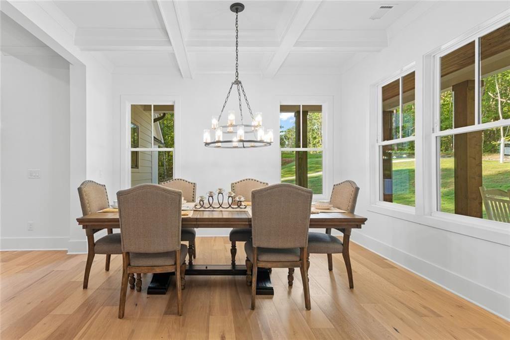 240 Highlands Ball Ground, GA 30107 - Photo 12 of 57 a dining room with furniture a chandelier and wooden floor